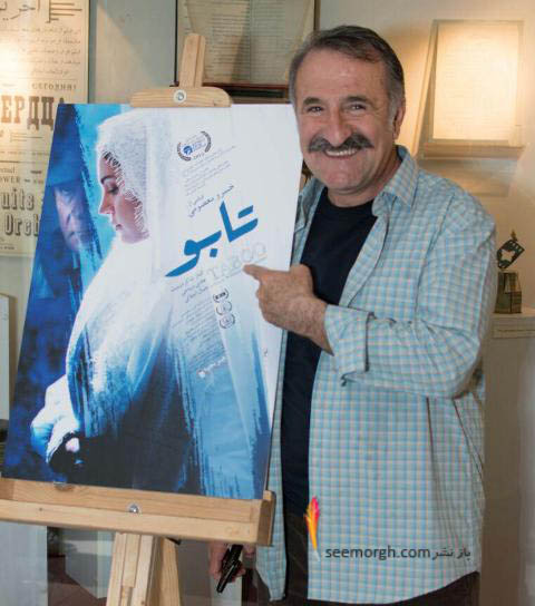 مهران رجبی در کنار پوستر فیلم تابو