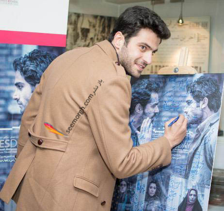 علی ضیاء درحال امضا کردن پوستر فیلم چهارشنبه