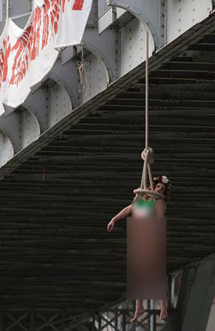 راشا تودی: آویزان شدن یک فمنیست نیمه‌برهنه از پلی در پاریس در اعتراض به سفر رئیس‌جمهور ایران+ تصاویر
