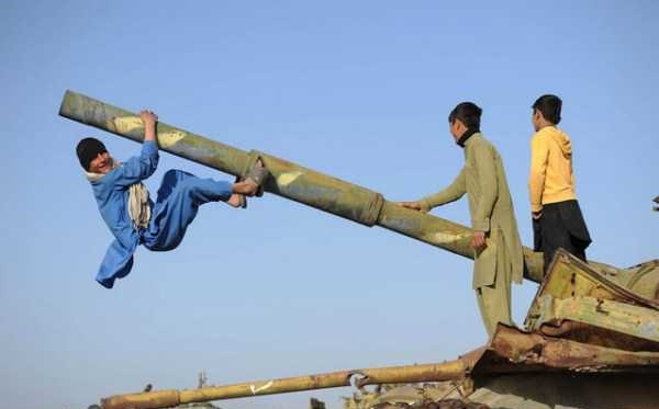 عکس/ بازی پسران نوجوان افغان با تانک های از دور خارج شده