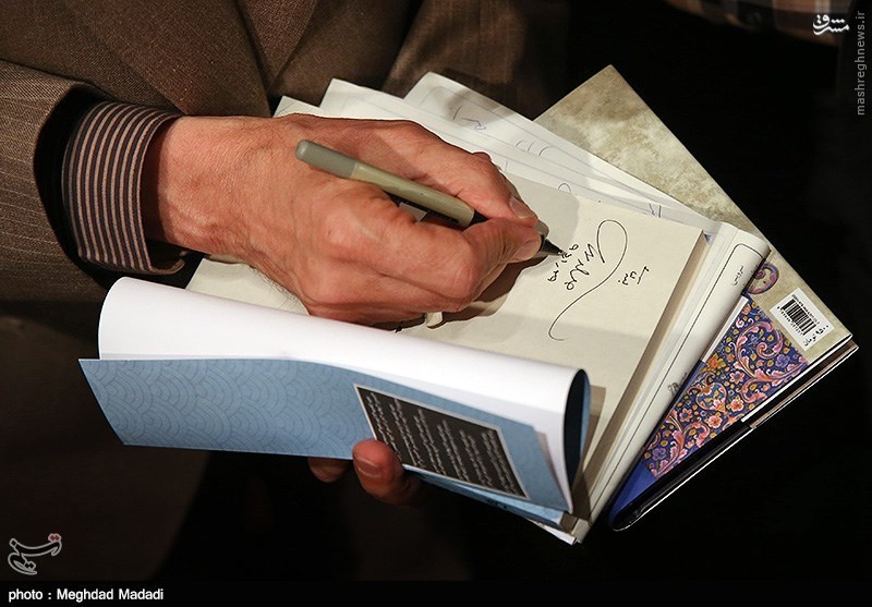 امضاء زدن حداد عادل روی کتابش