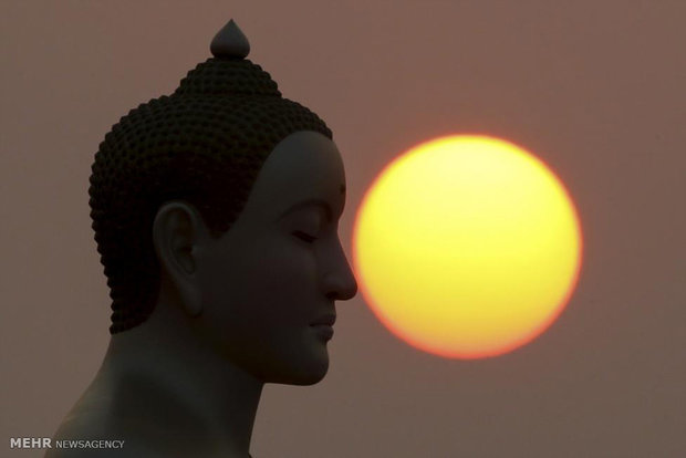 نمایی جالب از غروب خورشید کنار مجسمه بودا